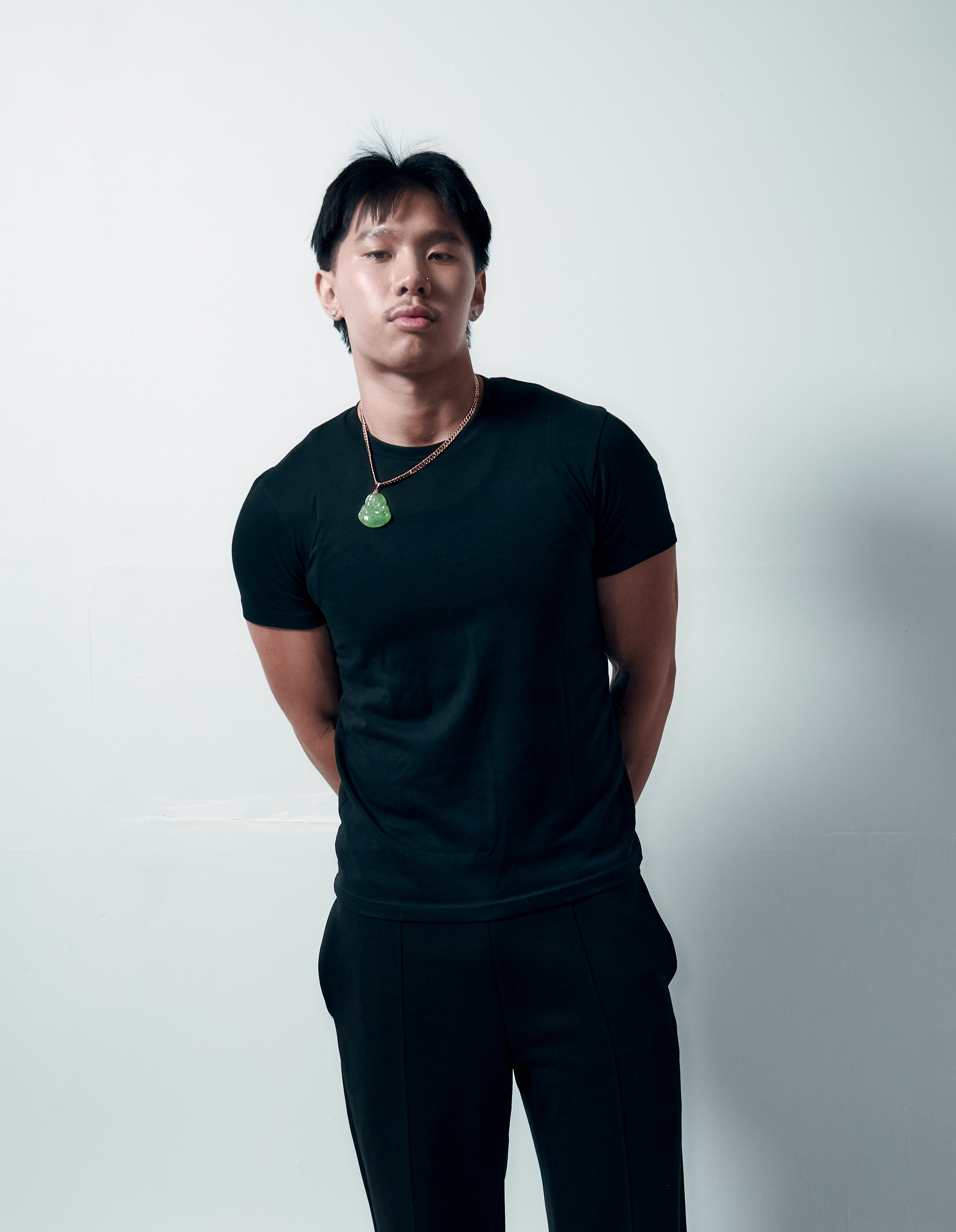 Studio portrait of a man in a black tee and trousers